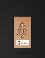 Decorațiune de Crăciun din lemn în formă de brad, prezentată pe un fundal elegant — accesoriu inclus în seturile cadou StoryBox.