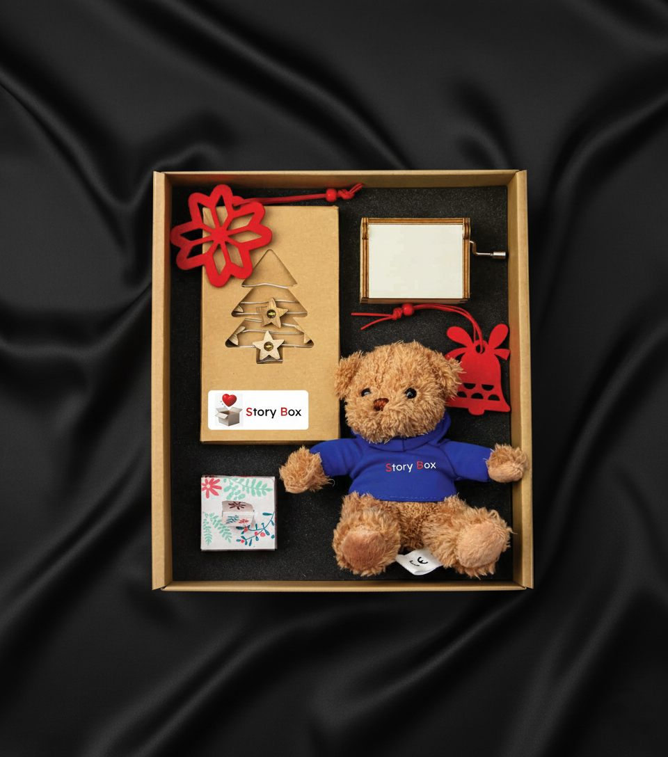 Set cadou StoryBox Miracolul Crăciunului cu ursuleț de pluș, decorațiuni roșii și suport foto, prezentat în cutie elegantă pe fundal negru satinat.